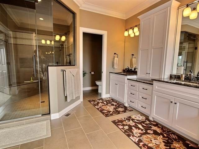 Foto di una stanza da bagno padronale tradizionale con ante bianche, doccia ad angolo e porta doccia a battente