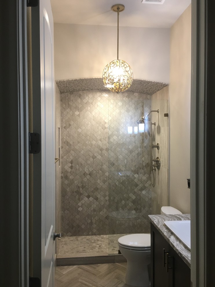 Idéer för ett mellanstort klassiskt badrum med dusch, med luckor med infälld panel, grå skåp, en dusch i en alkov, en toalettstol med separat cisternkåpa, grå kakel, kakelplattor, grå väggar, kalkstensgolv, ett nedsänkt handfat och bänkskiva i kvarts