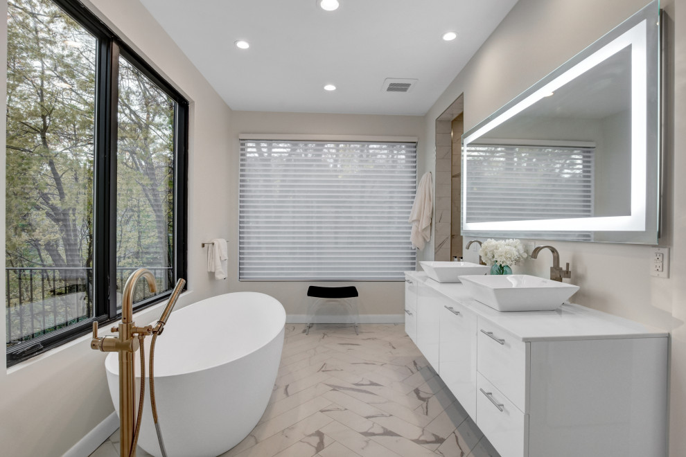 Bild på ett stort funkis vit vitt en-suite badrum, med släta luckor, vita skåp, ett fristående badkar, en dusch i en alkov, beige väggar, klinkergolv i porslin, ett fristående handfat och beiget golv