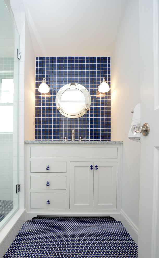 Imagen de cuarto de baño costero con baldosas y/o azulejos azules y puertas de armario blancas