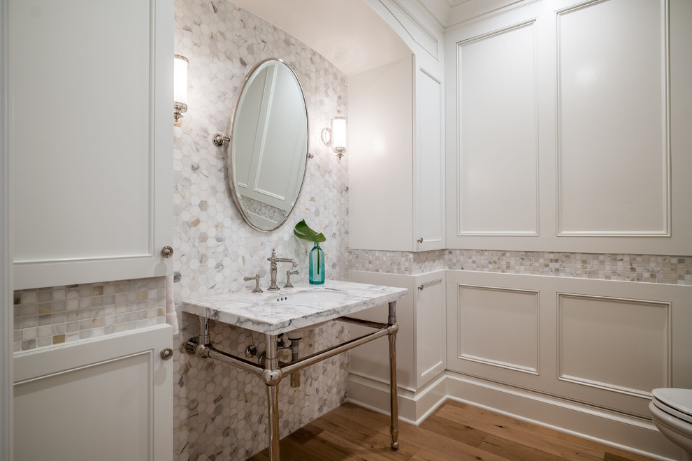 Example of a classic mosaic tile medium tone wood floor bathroom design in Los Angeles with marble countertops, recessed-panel cabinets, white cabinets, white walls and a console sink
