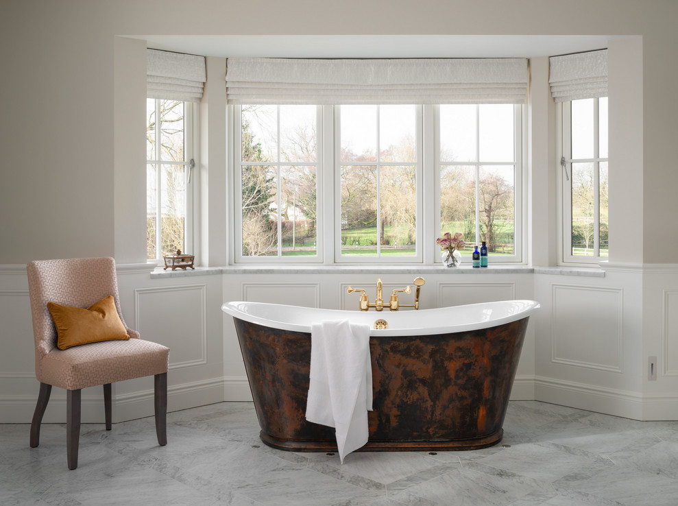 Photo of a large contemporary ensuite wet room bathroom in London with flat-panel cabinets, white cabinets, a freestanding bath, a one-piece toilet, grey tiles, marble tiles, grey walls, marble flooring, a console sink, marble worktops, grey floors, a hinged door and grey worktops.