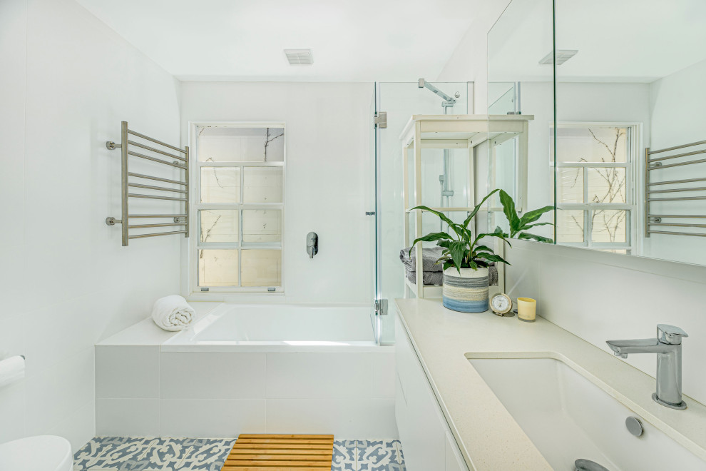 Réalisation d'une salle de bain design avec un placard à porte plane, des portes de placard blanches, une baignoire posée, un carrelage blanc, un mur blanc, un lavabo encastré, un sol gris, un plan de toilette beige, meuble simple vasque et meuble-lavabo suspendu.