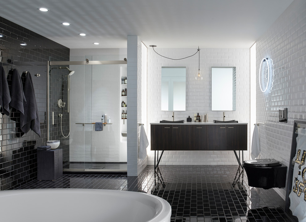 Пример оригинального дизайна: главная ванная комната среднего размера в стиле модернизм с фасадами островного типа, черными фасадами, отдельно стоящей ванной, душем в нише, инсталляцией, черно-белой плиткой, плиткой кабанчик, черными стенами, полом из керамической плитки, накладной раковиной, столешницей из искусственного камня, черным полом и душем с раздвижными дверями