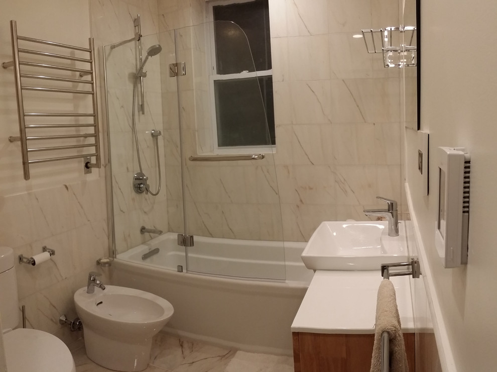 Esempio di una piccola stanza da bagno minimalista con ante lisce, ante in legno chiaro, lavabo a bacinella, bidè, piastrelle in pietra, pareti beige e pavimento in marmo