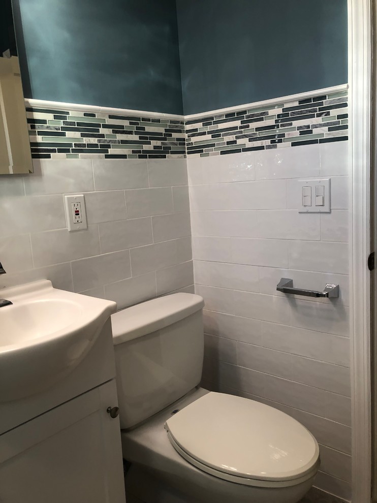 Inspiration pour une petite salle de bain principale minimaliste avec un placard à porte shaker, des portes de placard blanches, un carrelage vert, des plaques de verre, un mur blanc, un sol en carrelage de porcelaine, un sol gris et un plan de toilette blanc.