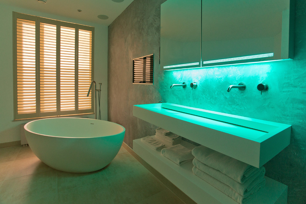Foto på ett funkis badrum, med ett fristående badkar och bänkskiva i akrylsten