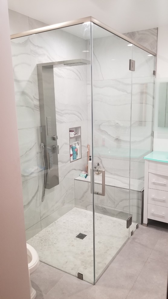 Inspiration pour une salle d'eau minimaliste de taille moyenne avec une douche d'angle, carreaux de ciment au sol et un plan de toilette en verre.