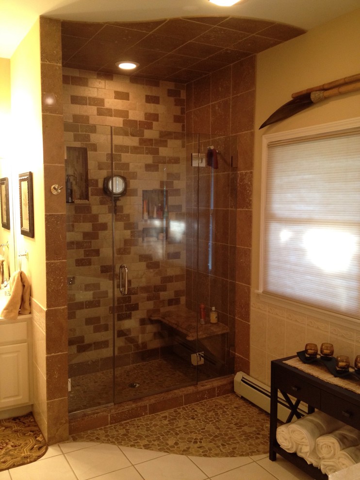 Пример оригинального дизайна: главная ванная комната среднего размера в морском стиле с унитазом-моноблоком, коричневой плиткой, галечной плиткой, бежевыми стенами, полом из керамической плитки и душевой комнатой
