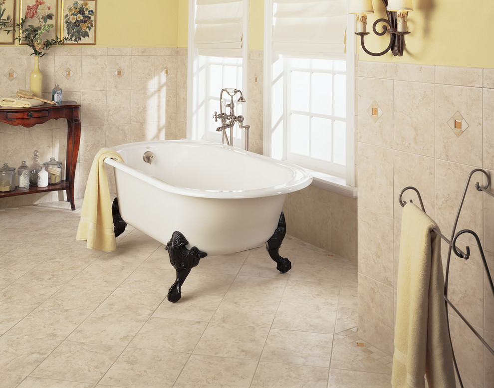 Idee per una stanza da bagno padronale tradizionale con vasca con piedi a zampa di leone, piastrelle beige, pareti gialle e pavimento con piastrelle in ceramica
