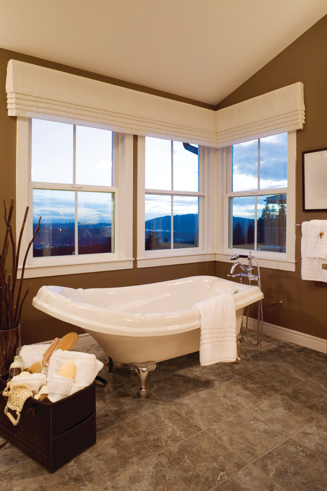 Esempio di una stanza da bagno chic con vasca con piedi a zampa di leone, piastrelle marroni e pareti marroni