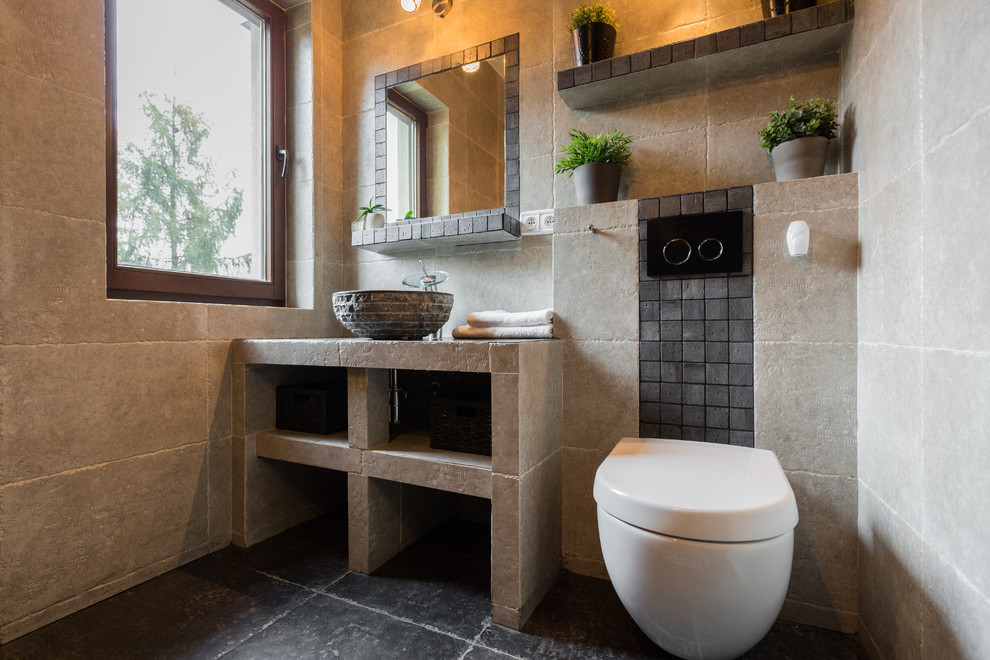 Medium sized rustic shower room bathroom in DC Metro with open cabinets, a wall mounted toilet, stone tiles, beige walls, concrete flooring and a vessel sink.