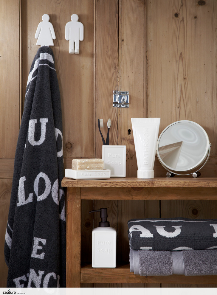 Bild på ett litet amerikanskt badrum för barn, med skåp i mellenmörkt trä, vita väggar, ljust trägolv och träbänkskiva