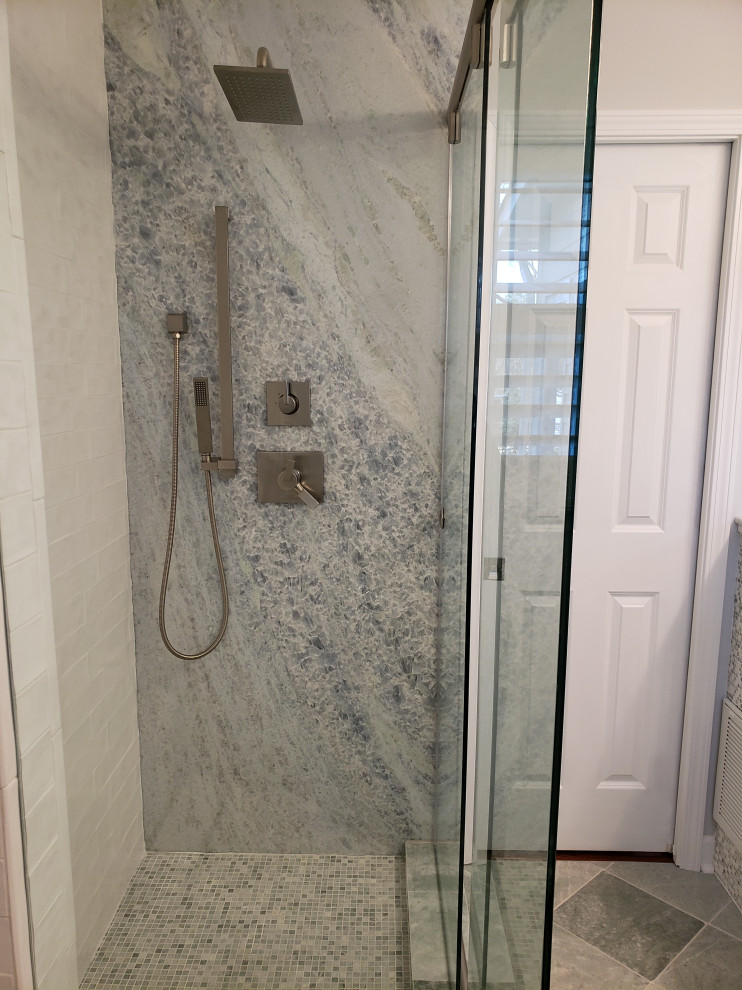 Small contemporary bathroom in Charlotte with a corner shower, multi-coloured tiles, stone tiles, white walls, mosaic tile flooring, green floors and a sliding door.