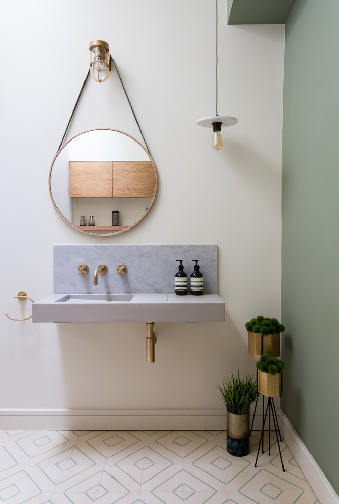 Diseño de cuarto de baño escandinavo con paredes blancas, lavabo integrado, suelo multicolor, encimeras grises y espejo con luz