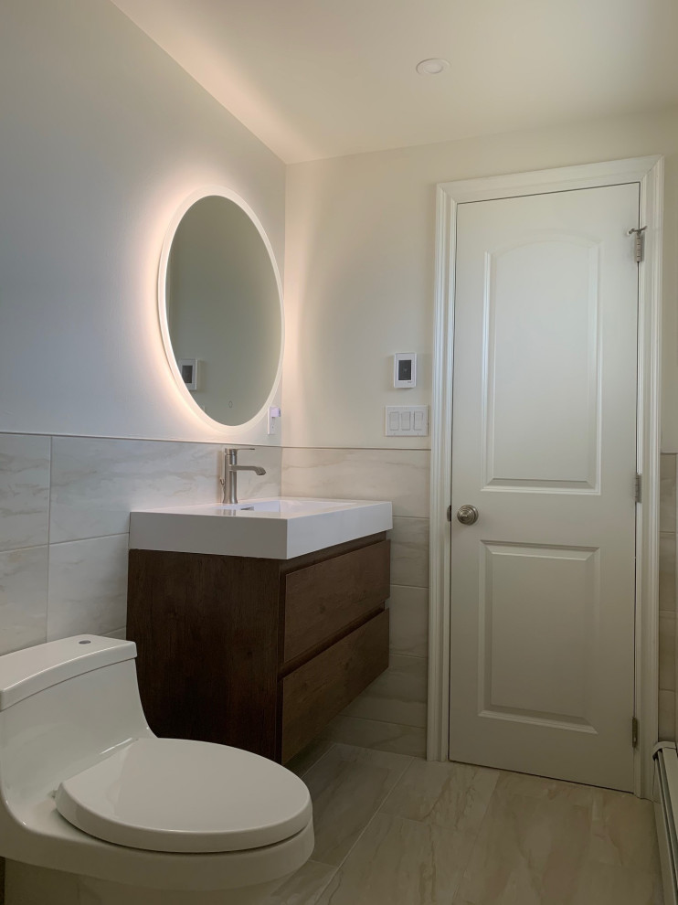 Inspiration pour une salle d'eau minimaliste en bois foncé de taille moyenne avec un placard à porte plane, un plan de toilette blanc, WC suspendus, un sol en carrelage de porcelaine et un lavabo intégré.