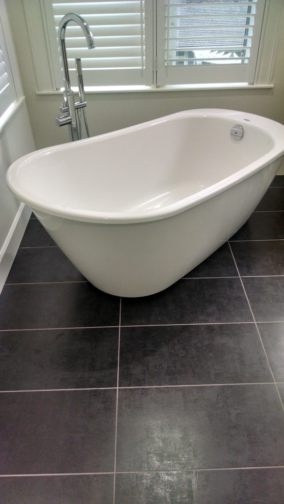 Пример оригинального дизайна: ванная комната в стиле модернизм с отдельно стоящей ванной, белыми стенами и полом из сланца