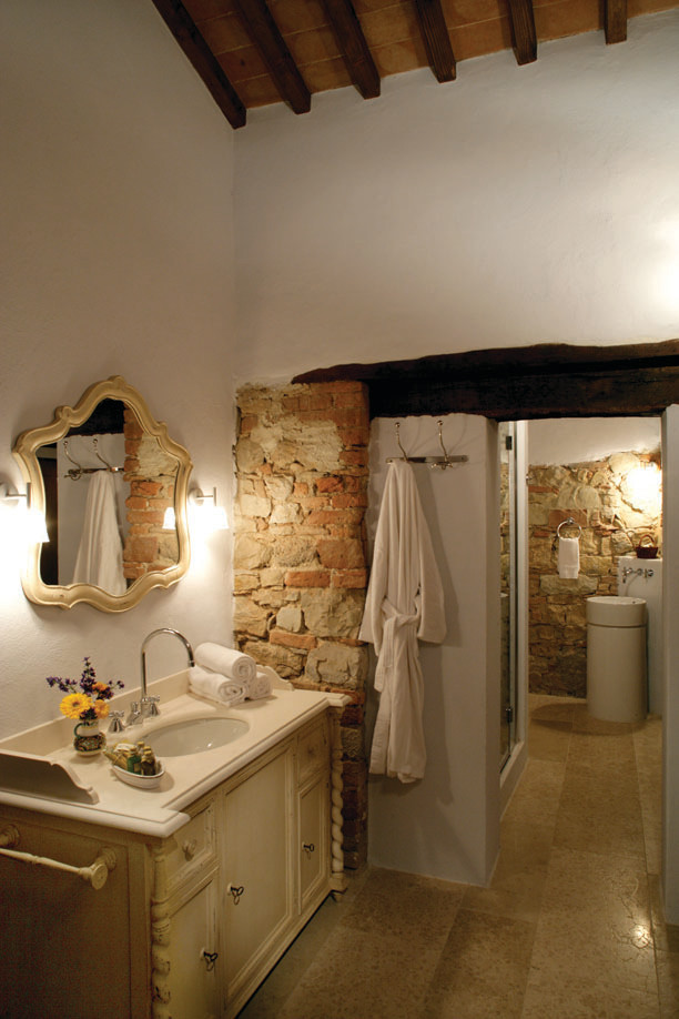 Immagine di una stanza da bagno mediterranea con ante con finitura invecchiata, piastrelle beige e pareti bianche