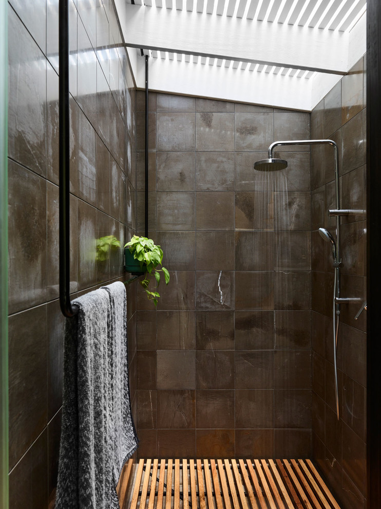 Cette photo montre une salle de bain moderne de taille moyenne avec une douche ouverte, WC suspendus, un carrelage gris, du carrelage en pierre calcaire, un mur gris, parquet clair et aucune cabine.