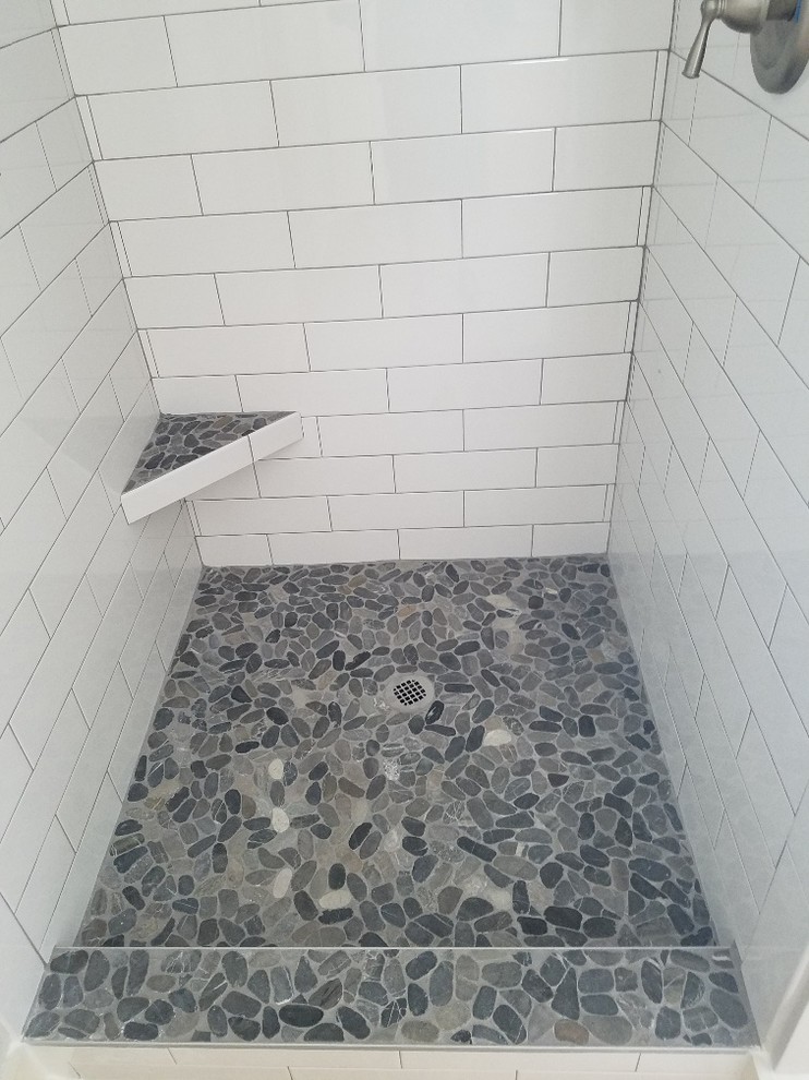 Klassisk inredning av ett mellanstort en-suite badrum, med ett platsbyggt badkar, en öppen dusch, vit kakel, glaskakel, grå väggar, cementgolv och kaklad bänkskiva