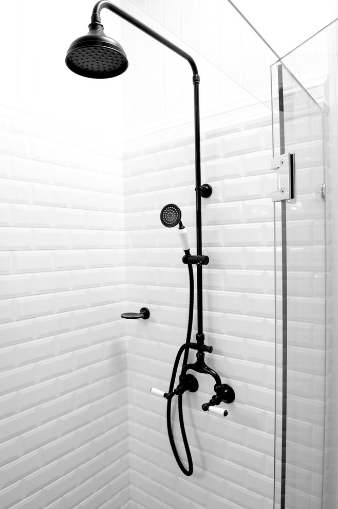 Foto di una stanza da bagno padronale moderna di medie dimensioni con ante con riquadro incassato, ante bianche, piastrelle bianche, piastrelle di cemento, doccia ad angolo, pareti bianche e lavabo sottopiano