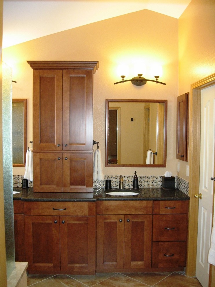 Photo of a large traditional ensuite bathroom in Denver with shaker cabinets, dark wood cabinets, an alcove shower, beige walls, ceramic flooring, a submerged sink and solid surface worktops.