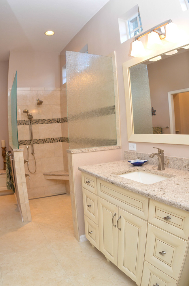 Large traditional ensuite bathroom in Tampa with raised-panel cabinets, white cabinets, a walk-in shower, a one-piece toilet, beige tiles, brown tiles, ceramic tiles, beige walls, travertine flooring, a submerged sink and granite worktops.