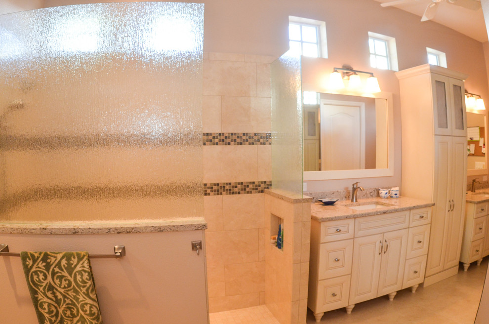 Cette photo montre une grande salle de bain principale chic avec un placard avec porte à panneau surélevé, des portes de placard blanches, une douche ouverte, WC à poser, un carrelage beige, un carrelage marron, des carreaux de céramique, un mur beige, un sol en travertin, un lavabo encastré et un plan de toilette en granite.