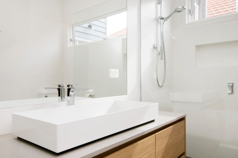 Cette image montre une salle de bain design avec un plan de toilette en quartz modifié.