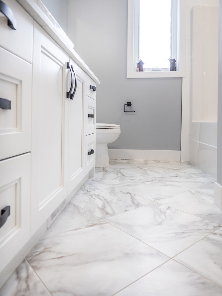 Foto di una stanza da bagno padronale design di medie dimensioni con ante con riquadro incassato, ante bianche, piastrelle multicolore, piastrelle in ceramica, pavimento in vinile, top in quarzite e pavimento bianco