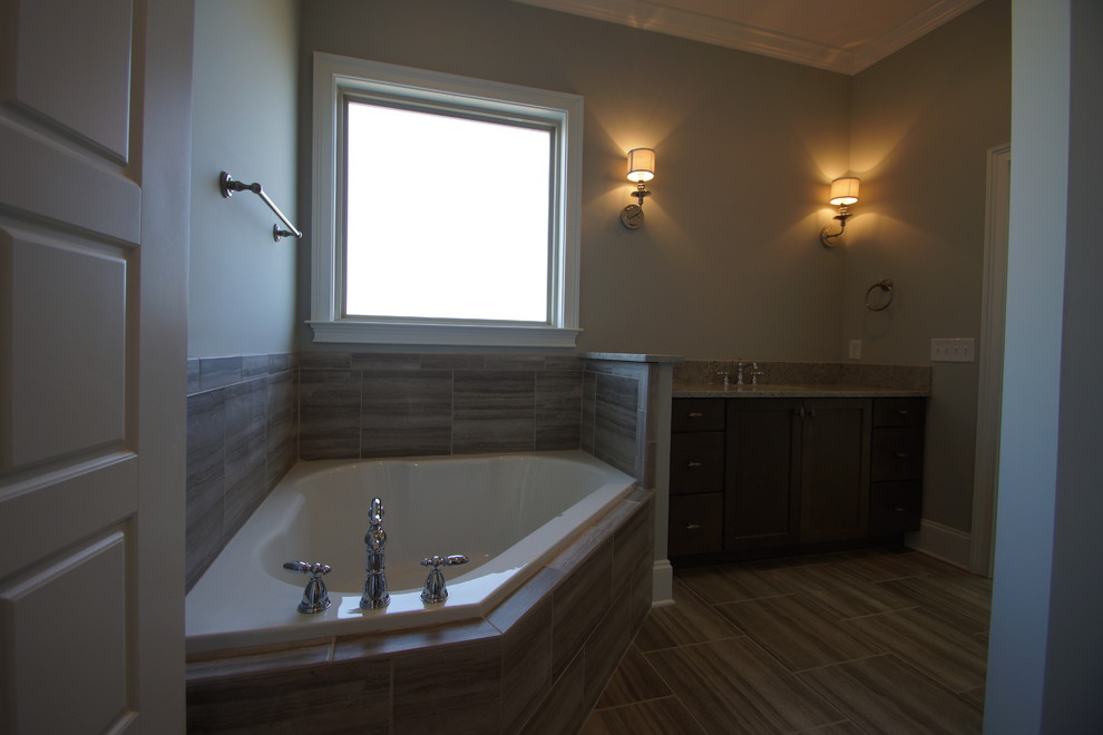 Ispirazione per una stanza da bagno padronale chic di medie dimensioni con lavabo sottopiano, ante in stile shaker, ante in legno bruno, top in marmo, vasca ad angolo, piastrelle grigie e pareti grigie