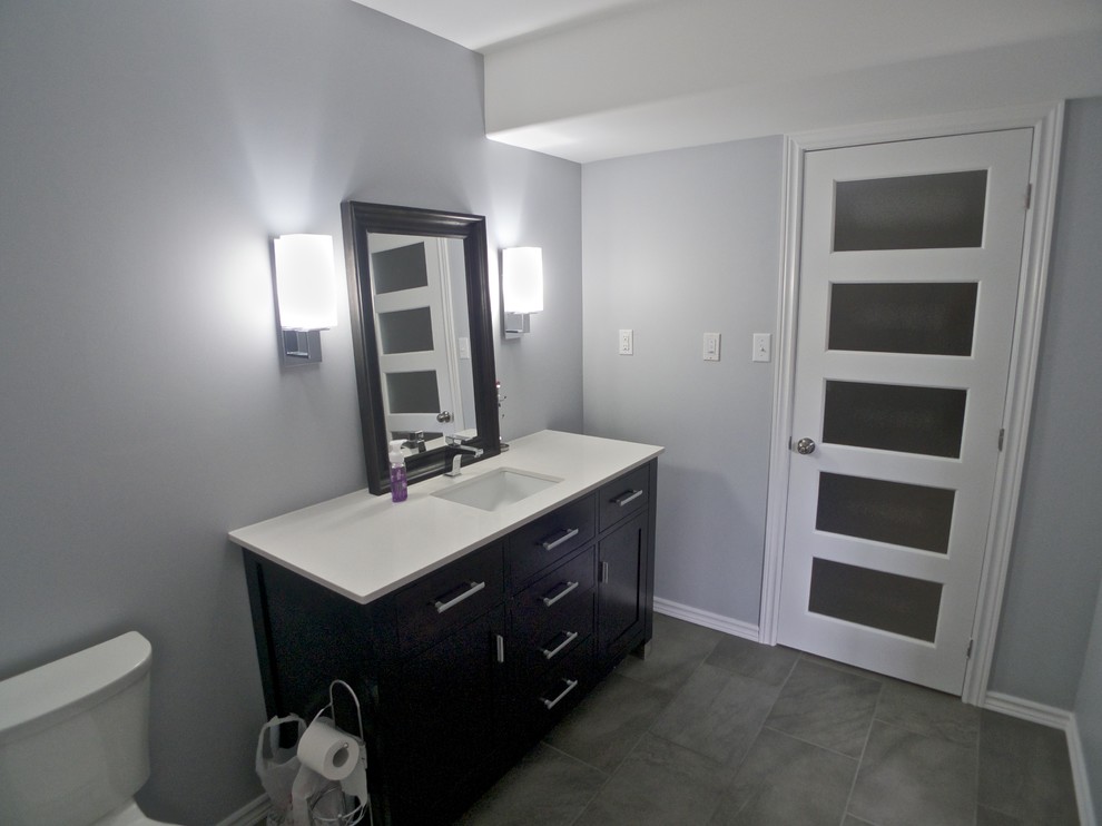 Пример оригинального дизайна: ванная комната среднего размера в стиле модернизм с плоскими фасадами, темными деревянными фасадами, столешницей из гранита и полом из керамической плитки