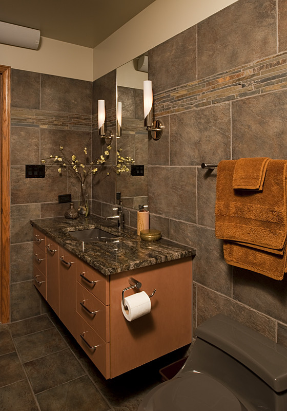 Photo of a small contemporary shower room bathroom in Chicago with flat-panel cabinets, medium wood cabinets, a one-piece toilet, grey tiles, ceramic tiles, grey walls, ceramic flooring, a submerged sink and engineered stone worktops.