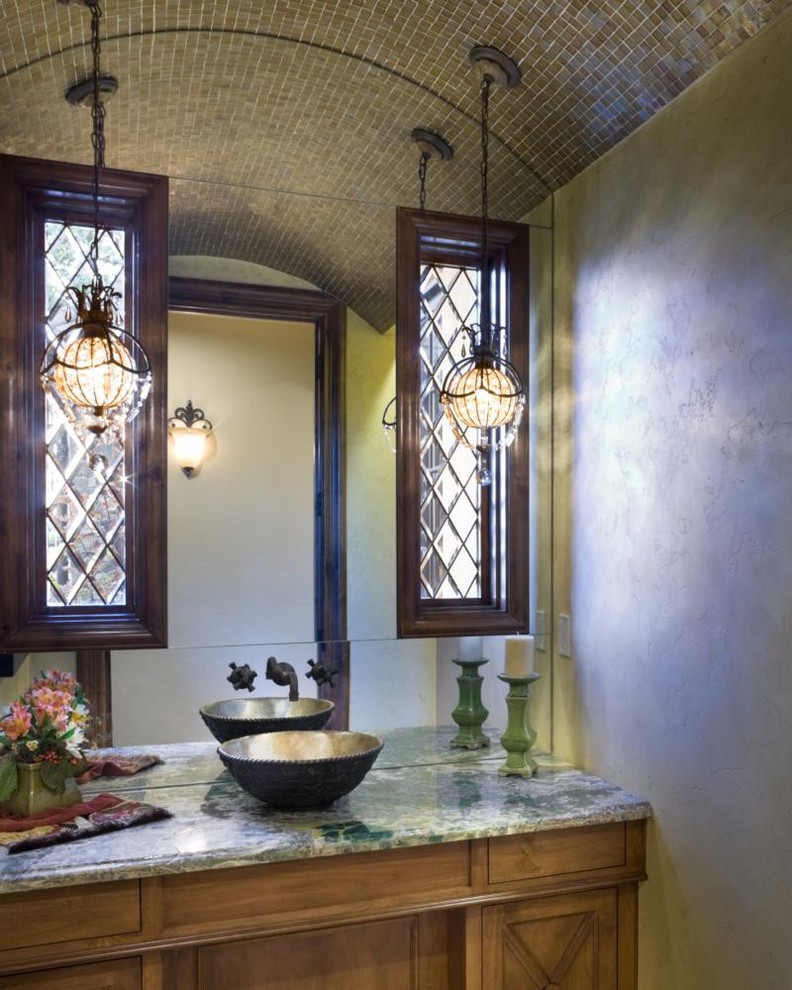 Idee per una stanza da bagno mediterranea con ante con riquadro incassato, ante in legno bruno, top in marmo, piastrelle grigie e piastrelle in pietra