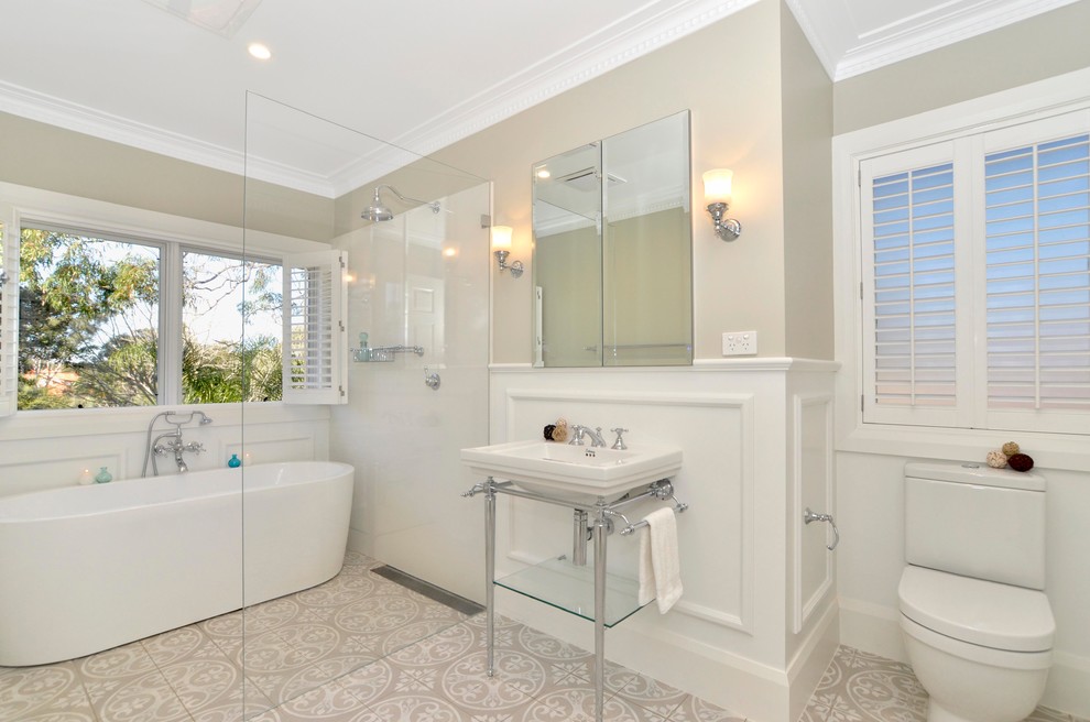 На фото: ванная комната среднего размера в классическом стиле с отдельно стоящей ванной, открытым душем, раздельным унитазом, бежевыми стенами, консольной раковиной и открытым душем с