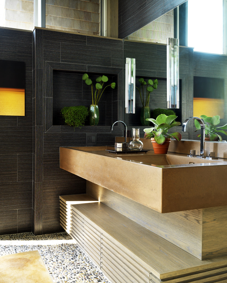 Cette image montre une salle de bain design en bois brun avec un lavabo intégré et un carrelage noir.