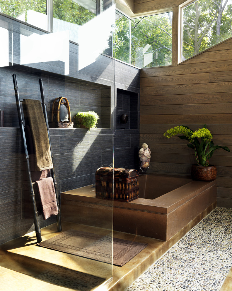Foto på ett funkis badrum, med en hörndusch, svart kakel och klinkergolv i småsten