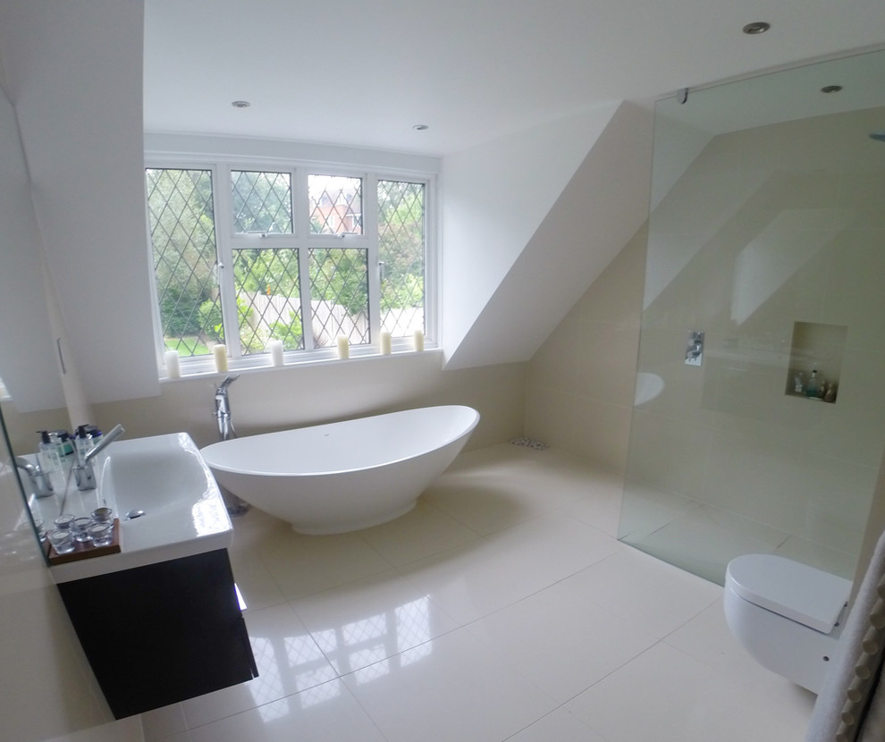 Exemple d'une grande salle de bain principale moderne en bois foncé avec un plan vasque, un placard à porte plane, une baignoire indépendante, une douche ouverte, WC suspendus, un carrelage beige, un carrelage de pierre, un mur beige et un sol en calcaire.