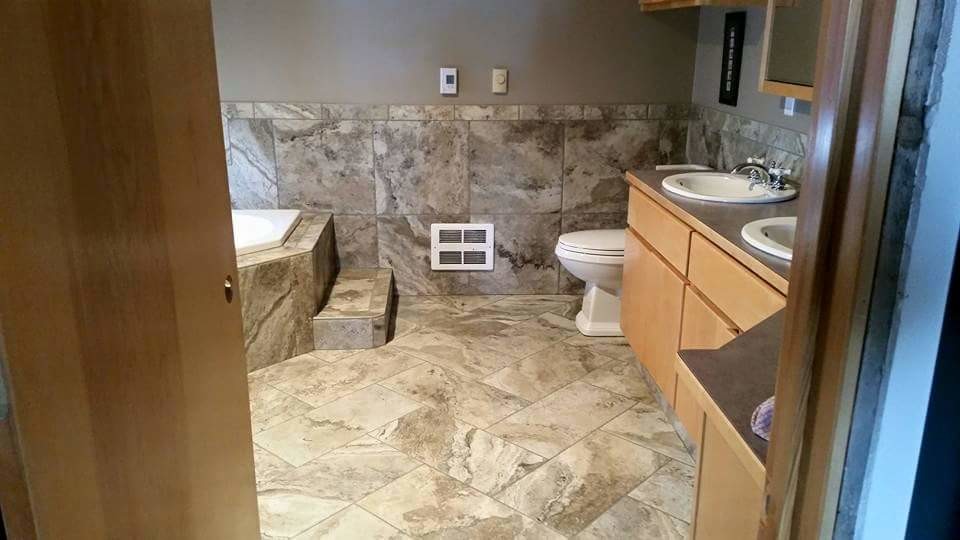 На фото: большая главная ванная комната в современном стиле с плоскими фасадами, светлыми деревянными фасадами, накладной ванной, угловым душем, раздельным унитазом, серой плиткой, каменной плиткой, серыми стенами, полом из цементной плитки, накладной раковиной, столешницей из искусственного камня, разноцветным полом и открытым душем с