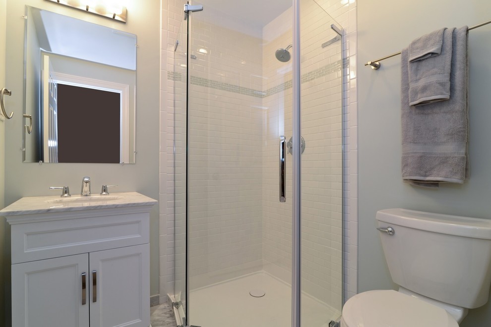 Corner shower - small modern 3/4 white tile and porcelain tile ceramic tile corner shower idea in Chicago with raised-panel cabinets, dark wood cabinets, a one-piece toilet, gray walls, a console sink and granite countertops