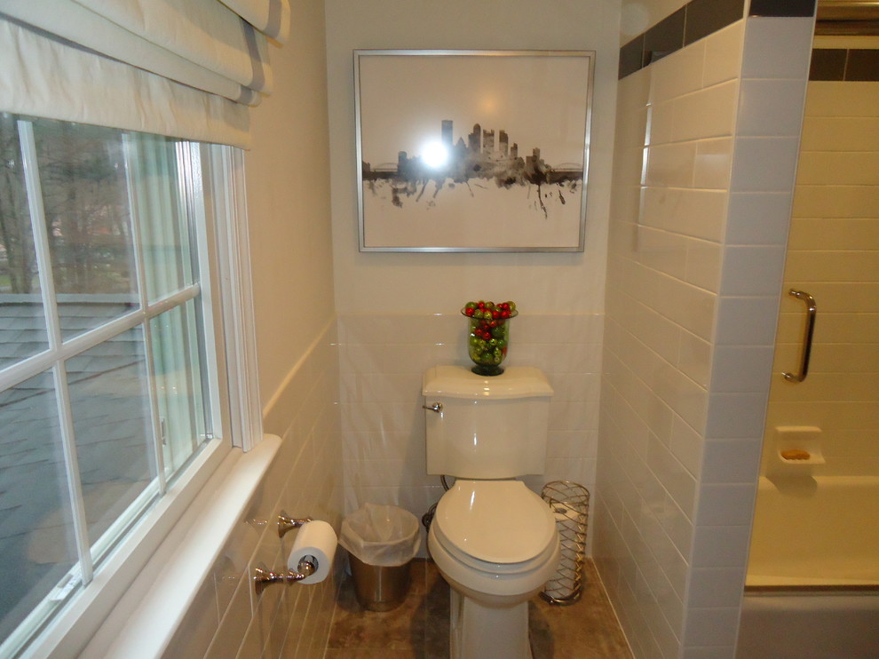 Klassisk inredning av ett mellanstort badrum med dusch, med luckor med upphöjd panel, svarta skåp, en dusch/badkar-kombination, en toalettstol med separat cisternkåpa, beige kakel, keramikplattor, vita väggar, klinkergolv i keramik, ett undermonterad handfat och bänkskiva i kvartsit