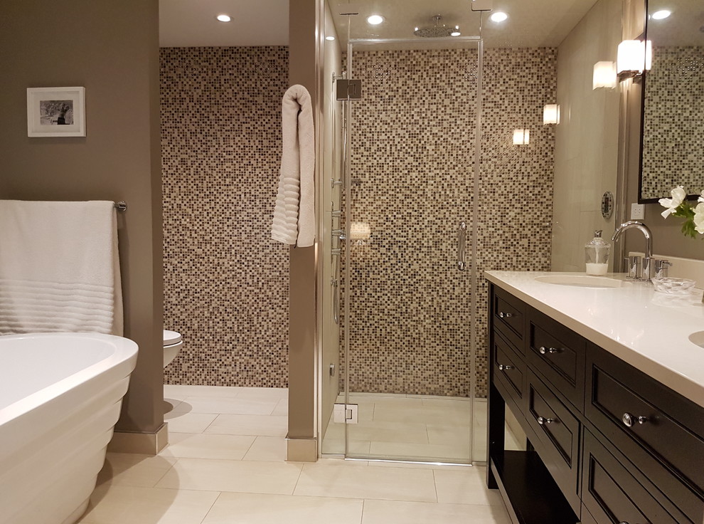 Design ideas for a medium sized contemporary ensuite bathroom in Montreal with recessed-panel cabinets, dark wood cabinets, a freestanding bath, an alcove shower, a one-piece toilet, beige tiles, brown tiles, white tiles, mosaic tiles, grey walls, porcelain flooring, a submerged sink, engineered stone worktops, beige floors and a hinged door.