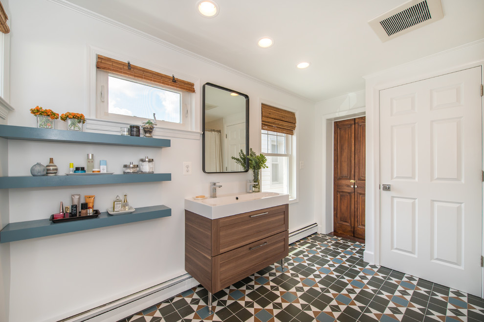Photo of a medium sized traditional shower room bathroom in Baltimore with flat-panel cabinets, medium wood cabinets, white walls, an integrated sink, multi-coloured floors, a shower curtain, white worktops, an alcove bath, a shower/bath combination, ceramic flooring and engineered stone worktops.