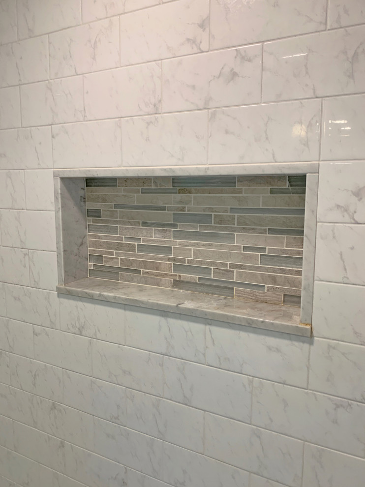 Inspiration for a mid-sized transitional white tile and subway tile porcelain tile and gray floor bathroom remodel in Philadelphia with raised-panel cabinets, white cabinets, a one-piece toilet, white walls, an undermount sink, quartz countertops and white countertops