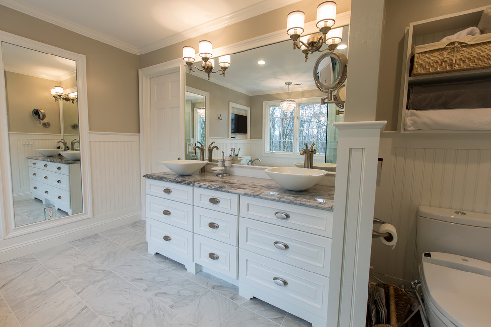 Mid-sized elegant master white tile and stone tile porcelain tile double shower photo in New York with a vessel sink, raised-panel cabinets, white cabinets, marble countertops, an undermount tub, a bidet and gray walls
