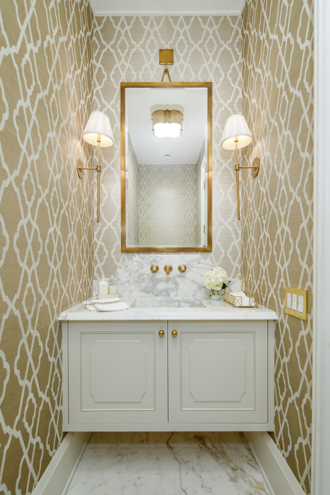 Cette image montre un WC et toilettes traditionnel avec un placard avec porte à panneau encastré, des portes de placard blanches, un mur beige, un lavabo intégré, un sol blanc et un plan de toilette blanc.