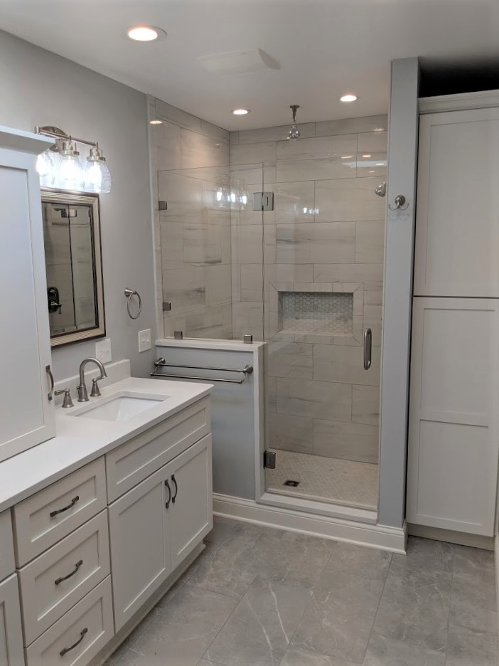 Inspiration for a mid-sized transitional master marble floor and gray floor alcove shower remodel in Cleveland with shaker cabinets, white cabinets, a one-piece toilet, gray walls, an undermount sink, granite countertops, a hinged shower door and white countertops