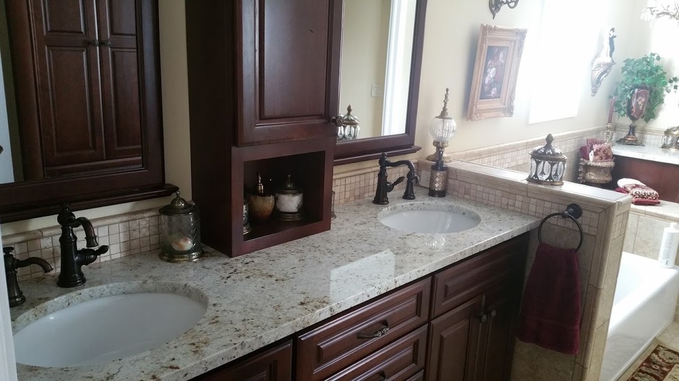 Klassisches Badezimmer En Suite mit Unterbauwaschbecken, profilierten Schrankfronten, dunklen Holzschränken und Granit-Waschbecken/Waschtisch in Las Vegas
