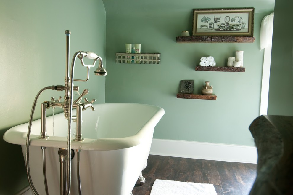 Aménagement d'une salle de bain principale bord de mer de taille moyenne avec une baignoire sur pieds, un mur vert, parquet foncé et un sol marron.