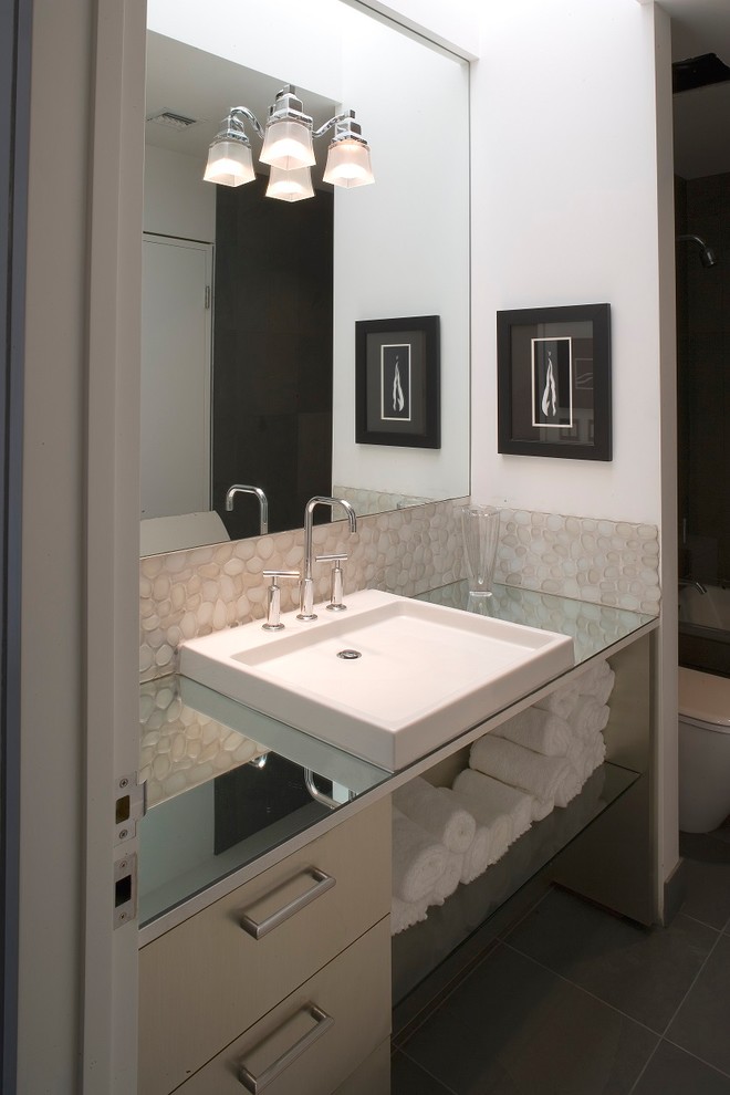Idee per una stanza da bagno con doccia design di medie dimensioni con nessun'anta, ante beige, WC monopezzo, piastrelle di ciottoli, pareti bianche, pavimento con piastrelle in ceramica, lavabo rettangolare, top in vetro e pavimento grigio